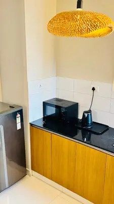 a kitchen with a black microwave on a counter at BOHO Living Kochi Airport in Ernakulam