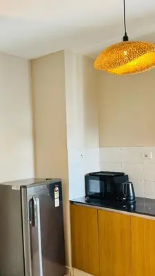 a kitchen with a microwave and a refrigerator at BOHO Living Kochi Airport in Ernakulam