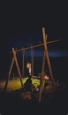 a group of people sitting on a swing at night at Misty Colina in Kottakamboor