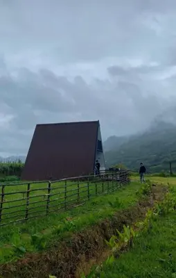 a barn on top of a hill with a fence at Misty Colina in Kottakamboor
