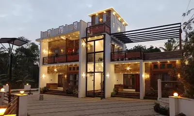 a large house with lights on it at night at RiverBank Gardens, Mananthavady, Wayanad in Mananthavady