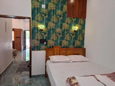 a bedroom with a bed and a green wallpaper at RiverBank Gardens, Mananthavady, Wayanad in Mananthavady