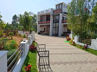 a building with two chairs in front of it at RiverBank Gardens, Mananthavady, Wayanad in Mananthavady
