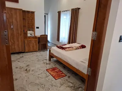 a small bedroom with a bed and a bathroom at RiverBank Gardens, Mananthavady, Wayanad in Mananthavady