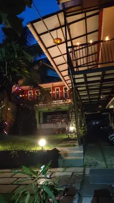 a night view of a building with a patio with lights at NEST nature homestay in Kalpetta