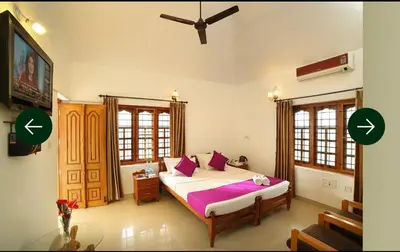 a bedroom with a large bed with purple pillows at The Trio in Kalpetta