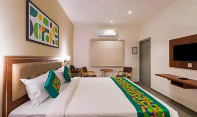 a hotel room with a bed and a tv at Treebo Global Orchid in Mysore