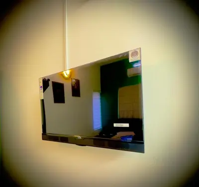 a mirror hanging on a wall in a room at Tokyoz Inn Calicut in Kunnamangalam