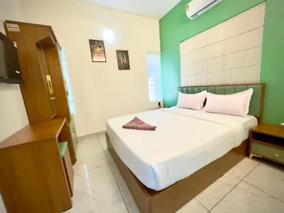 a bedroom with a bed and a television in it at Tokyoz Inn Calicut in Kunnamangalam