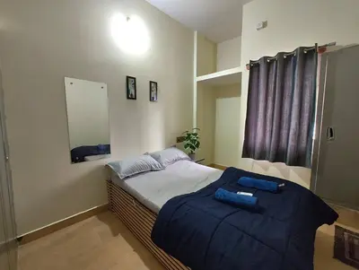 a bedroom with a bed with a blue blanket at Galasy in Narasimharaja Puram