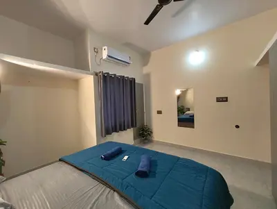 a bedroom with a large bed with a blue blanket at Galasy in Narasimharaja Puram