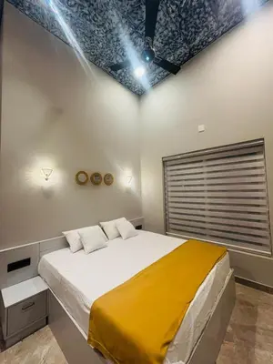 a bedroom with a large bed with a yellow blanket at Hira Homestay Wayanad in Pinangode