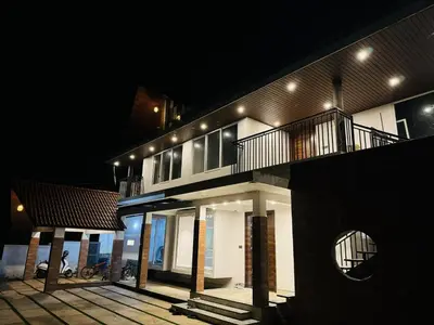 a house with lights on the side of it at night at Hira Homestay Wayanad in Pinangode