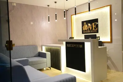 a room with two couches and a podium with a sign at Elite Group Mysore in Mysore
