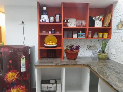 a kitchen with a counter and a refrigerator at Hridayam Hill view nest in Marayoor