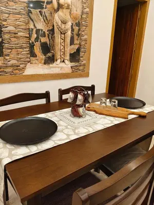 a wooden table with a sink and a painting on the wall at Hridayam Hill view nest in Marayoor