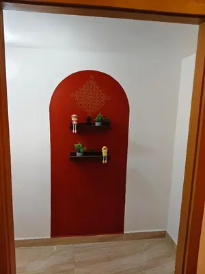 a red wall with some plants on a shelf at Hridayam Hill view nest in Marayoor