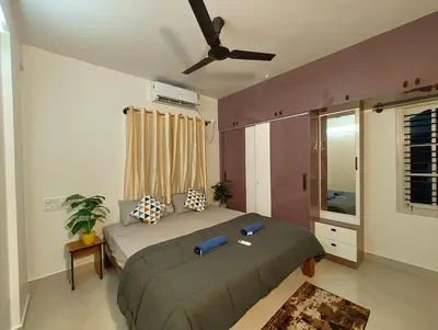 a bedroom with a bed and a ceiling fan at Namasv 2BHK AC House in Narasimharaja Puram