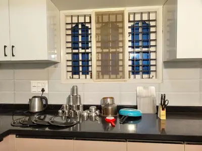 a kitchen counter with pots and pans on a stove at Namasv 2BHK AC House in Narasimharaja Puram