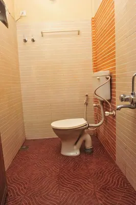 a bathroom with a toilet in a stall at Alfa Tourist Home, Batheri in Sultan Bathery