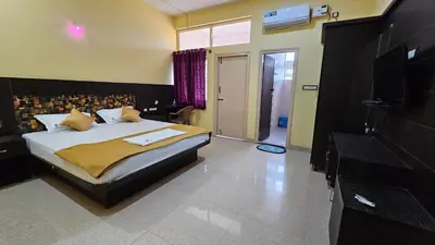 a bedroom with a bed and a television in a room at Corcordium by ssr in Bilikere