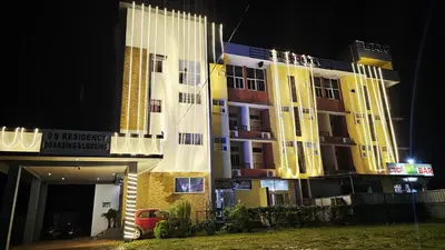 a building with a car parked in front of it at night at Corcordium by ssr in Bilikere
