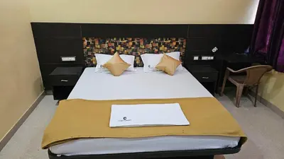 a bedroom with a bed with a laptop on it at Corcordium by ssr in Bilikere