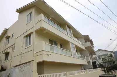 a large yellow building with a balcony at The Dew Nest in Ooty
