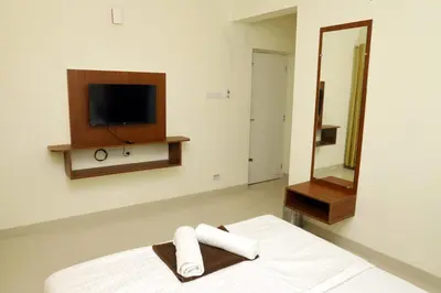 a bedroom with a bed with a mirror and a tv at The Dew Nest in Ooty