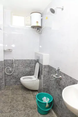a bathroom with a toilet and a sink at The Dew Nest in Ooty