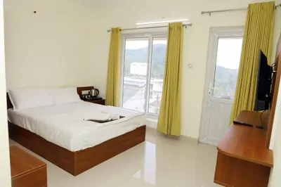 a bedroom with a bed and a tv and a window at The Dew Nest in Ooty