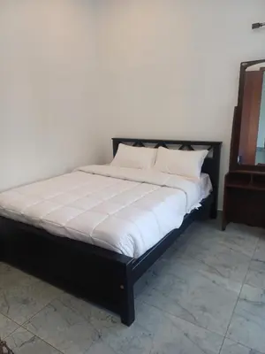 a bed with white sheets and pillows in a room at Prithivee Homestay in Kotagiri