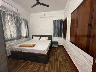 a bedroom with a bed and a ceiling fan at Western Castle Stay n lawn in Coimbatore