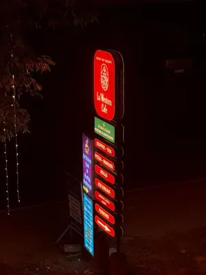 a sign with many signs on it in the dark at Western Castle Stay n lawn in Coimbatore