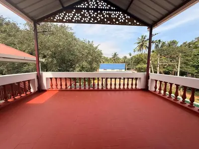 a balcony of a house with a roof at Western Castle Stay n lawn in Coimbatore