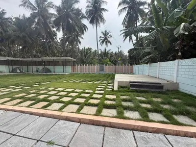 a field of grass with palm trees in the background at Western Castle Stay n lawn in Coimbatore