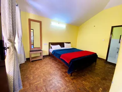 a bedroom with a bed with a red blanket at Skyline Haven cottage ll in Ooty