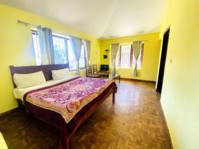 a bedroom with a bed in a room with yellow walls at Skyline Haven cottage ll in Ooty