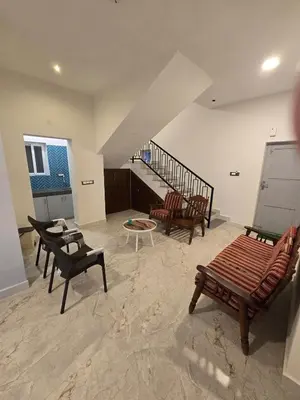 a living room with chairs and a stair case at The Brook by Turquoise Villas in Kodaikānāl