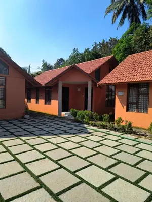 a house with a tiled driveway in front of it at Mystic Rock Staycations in Mannārakkāt