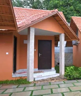 a small house with a black door on it at Mystic Rock Staycations in Mannārakkāt