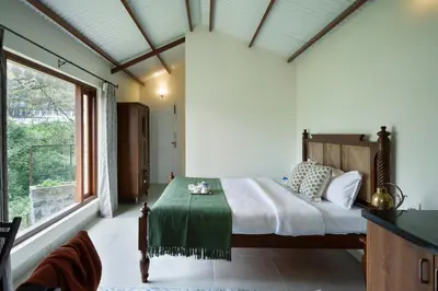 a bedroom with a bed and a large window at SaffronStays Oakridge Cottage in Coonoor