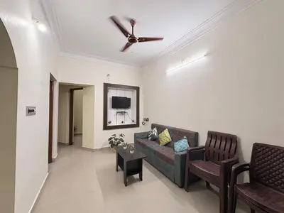 a living room with a couch and a ceiling fan at Kamadhenu Homestay, Comapact 2BHK OPP Mysore zoo B in Mysore