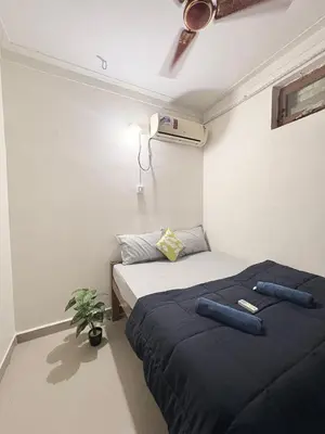 a bedroom with two beds and a plant in it at Kamadhenu Homestay, Comapact 2BHK OPP Mysore zoo B in Mysore