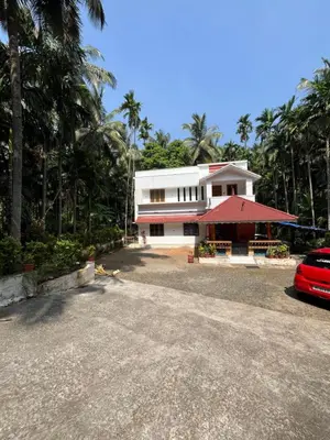 a house with a red car parked in front of it at Idachirakkal homestay in Palghat