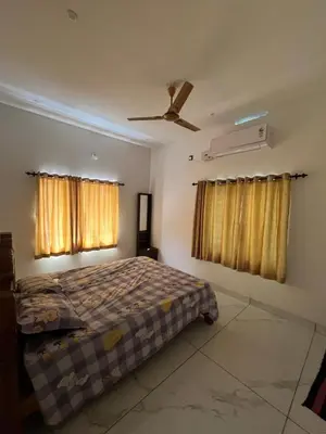 a bedroom with a bed and two windows at Idachirakkal homestay in Palghat