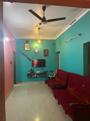 a living room with a red couch and a tv at Idachirakkal homestay in Palghat