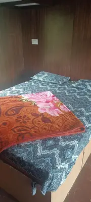 a bed with a colorful quilt on top of it at Bison valley in Ooty
