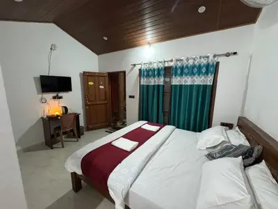 a bedroom with a large bed and a television at Manuvan Estate Stay in Kushālnagar