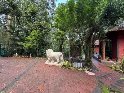 a statue of a white dog on a brick yard at Manuvan Estate Stay in Kushālnagar